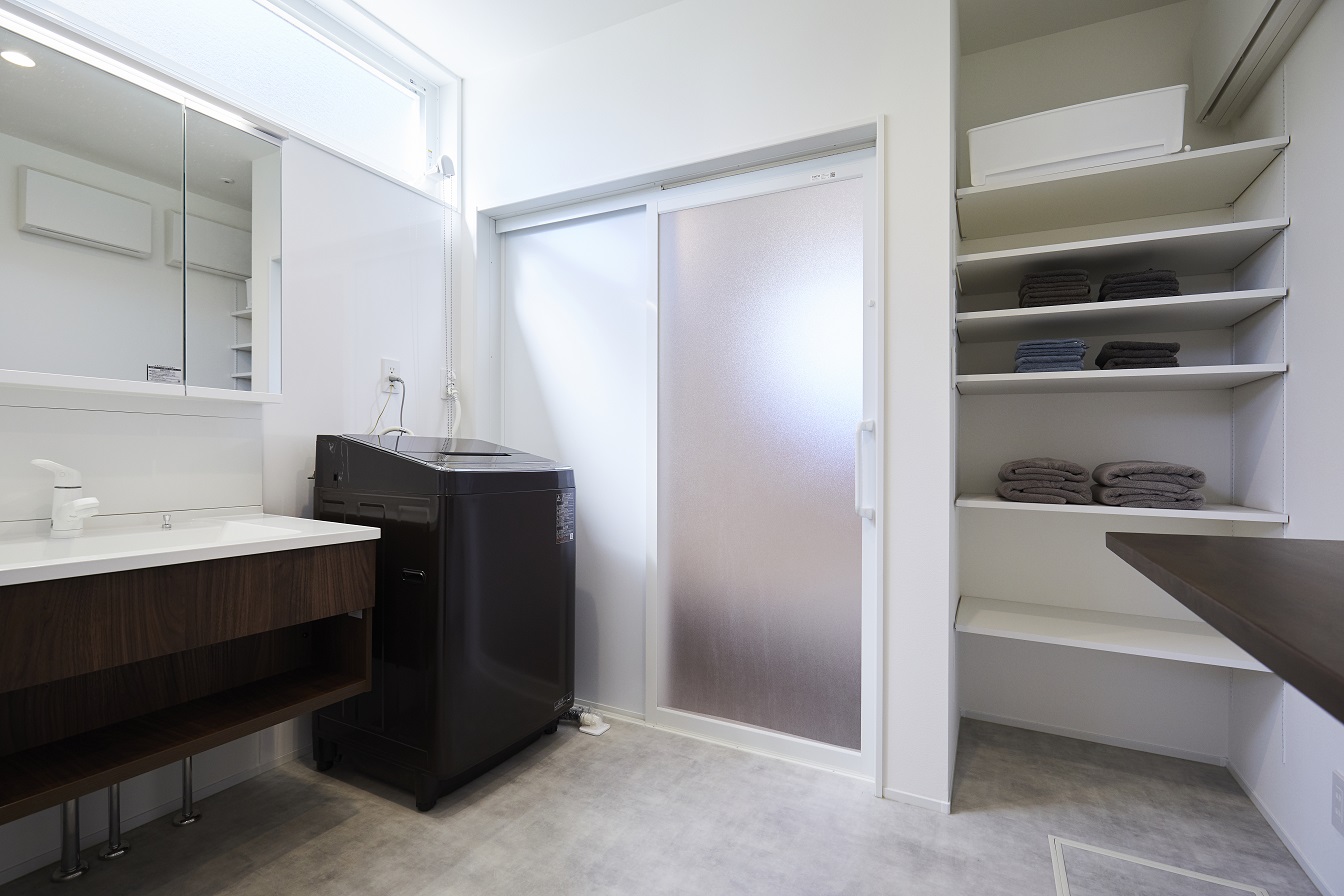広々とした洗面室には折り畳みができる作業カウンターを設置。浴室のドアは引き戸にすることで開口部が広くゆとりが持てるのと、スタイリッシュに見せることができます。