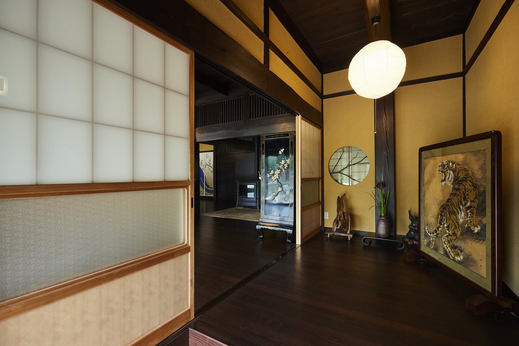 意匠性の高い日本の伝統的な丸窓を活かした玄関。入口からはもちろん、反対から見ても枝のシルエットが映り、とっても美しいです。