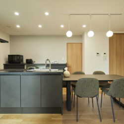 ダークトーンのキッチンが空間を引き締める上質なダイニング