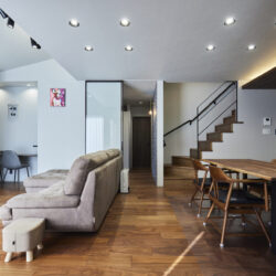 石目調のアクセントウォールが空間を引き締める、洗練されたリビングデザイン