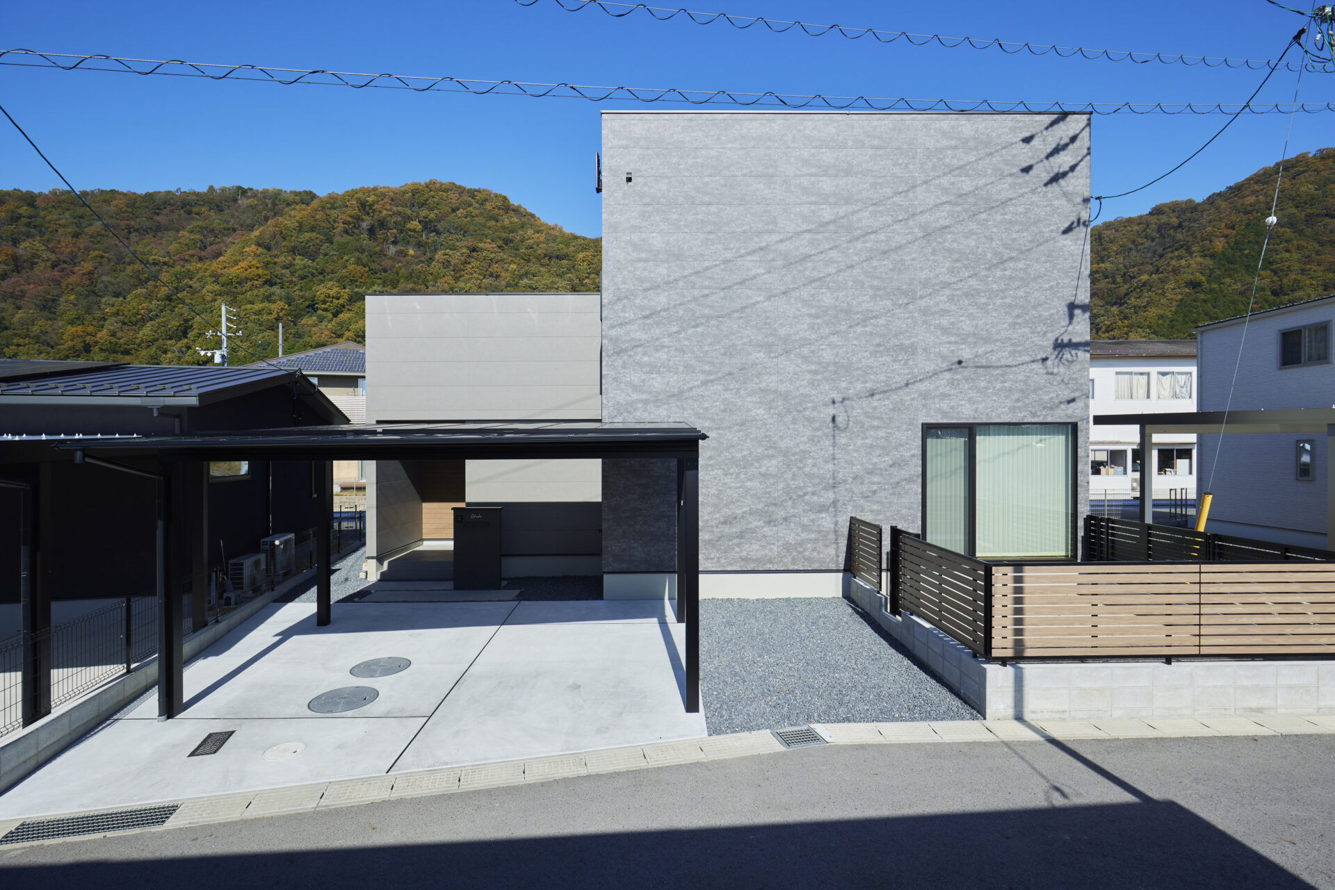 理想を詰め込んだ外観は、異なるトーンのグレーを組み合わせた美しいボックス型デザイン。質感のある大きなブロックと、滑らかなキューブを重ねることで、シンプルながらも立体感と洗練された存在感を生み出しました。玄関まわりは壁を少し奥に引き込んだインナーアプローチ（庇のある形状）になっており、雨の日でも鍵を開けるときなどに身体や荷物が濡れにくい、日々の暮らしに配慮した設計になっています。
