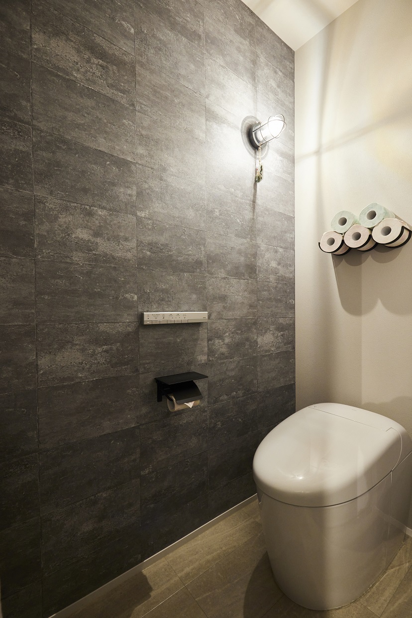 落ち着いた内装のお手洗い。トイレはタンクレスで、スタイリッシュなリモコンを採用されているためスッキリした空間に。